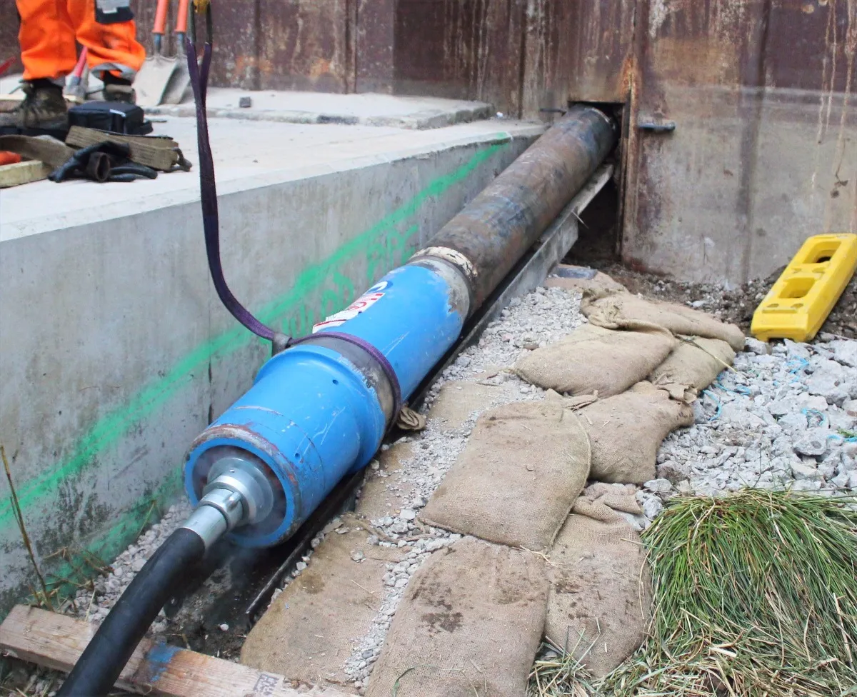 Trenchless crossing installation beneath a retaining wall